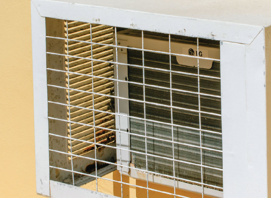 detail of an air-conditioned on a yellow wall.
