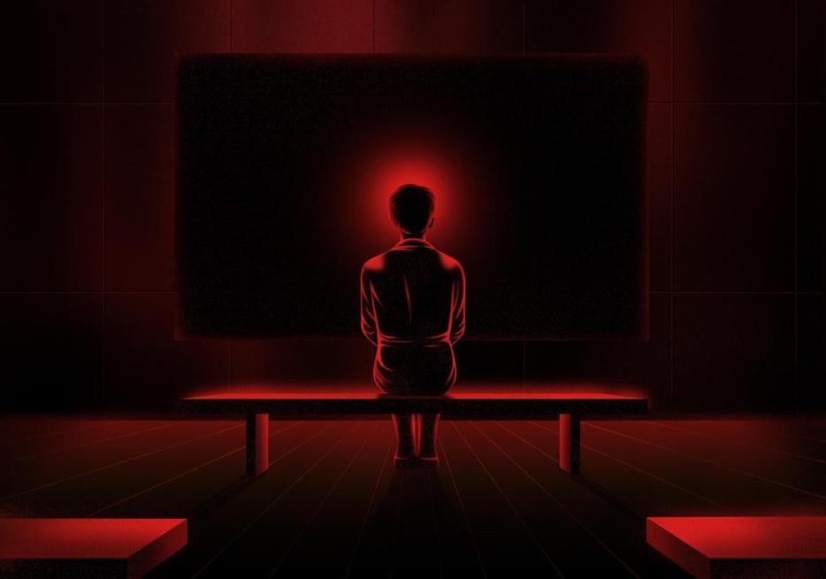 The back of a female figure sitting on a bench, with a red halo around her head, against a background of a dark projection screen.