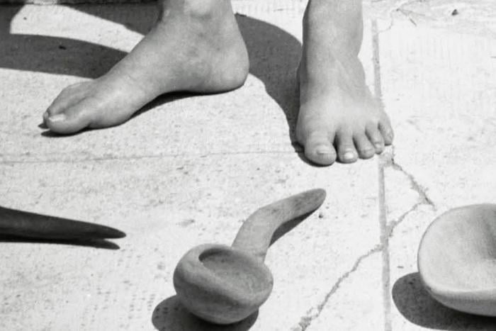 A crop of an image from Deborah Levy's book cover, a black and white photograph of feet with a spoon.