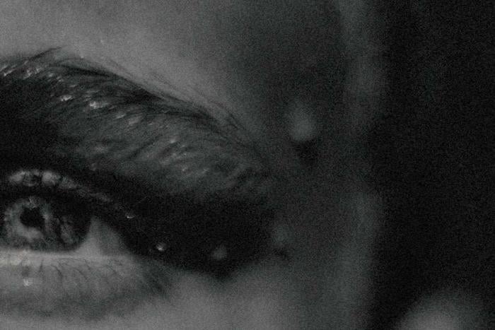 A close up, black and white image of a woman's eye 