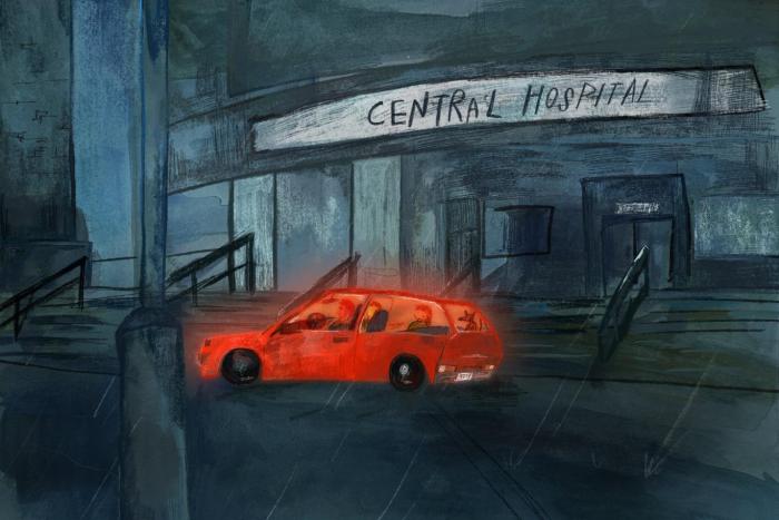A glowing red car sits outside of a hospital
