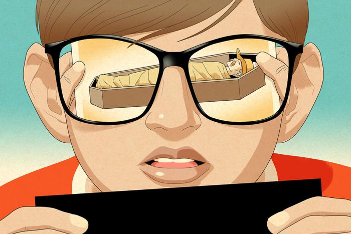 A person wearing sunglasses looking at an image of someone in a coffin, which is reflected in their sunglasses 