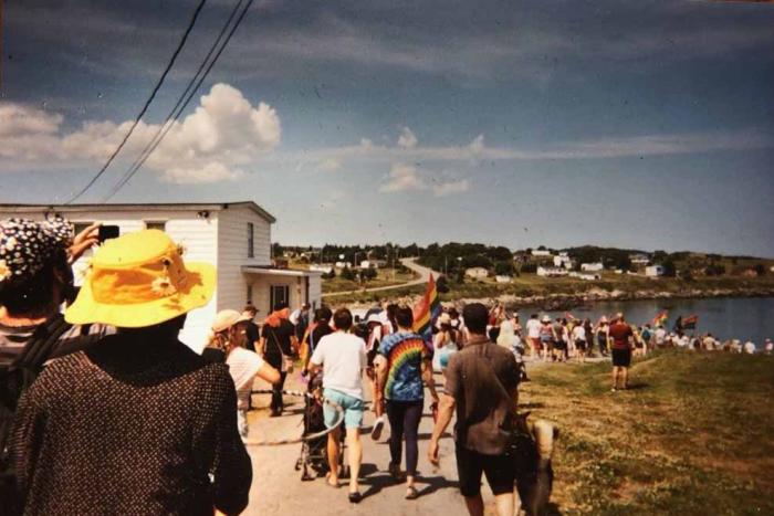 A group of people walking towards the beach 